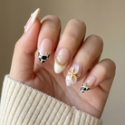 Hand with intricately designed nails against a neutral background