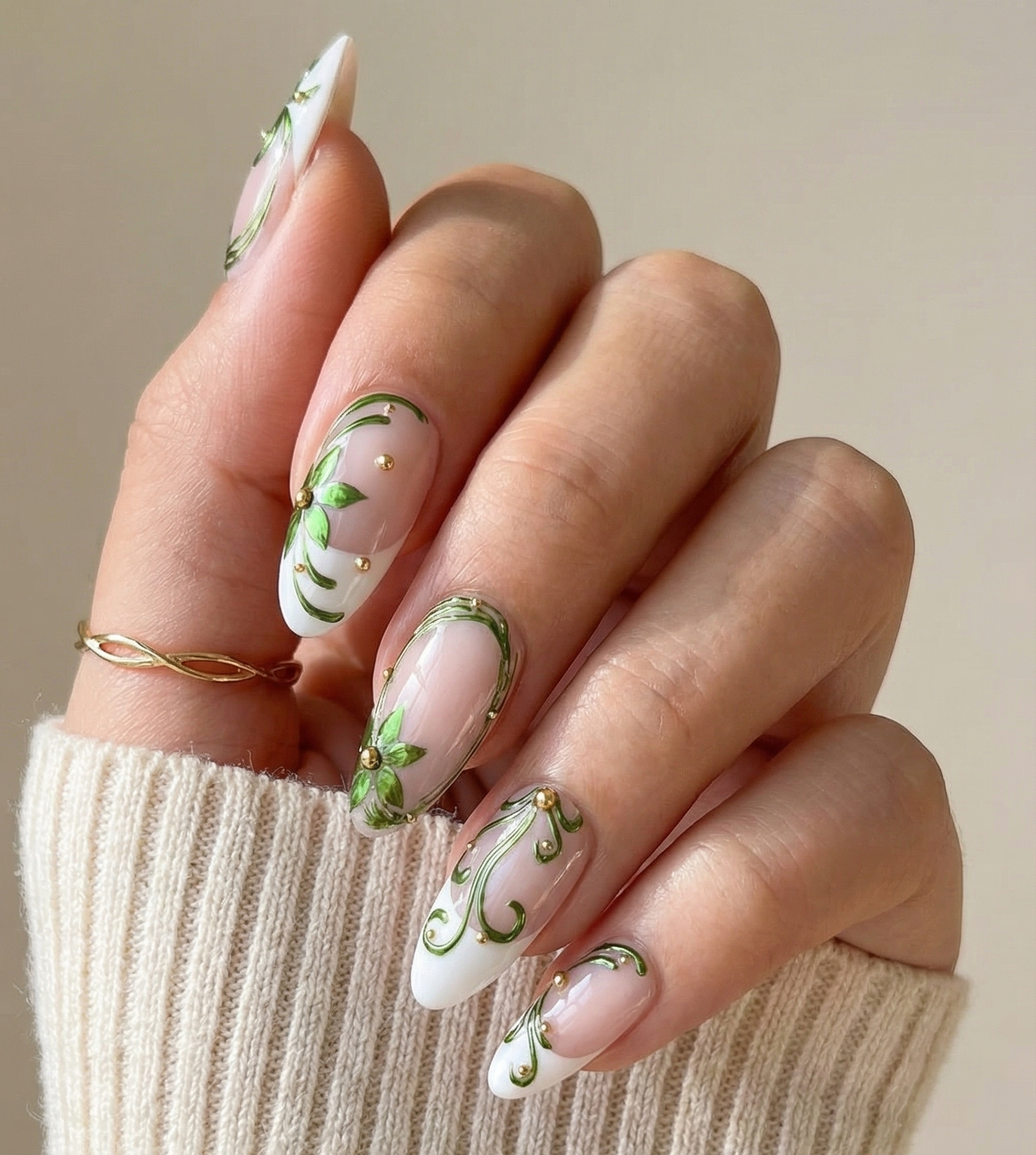Hand with decorative nail art holding a beige sleeve against a neutral background